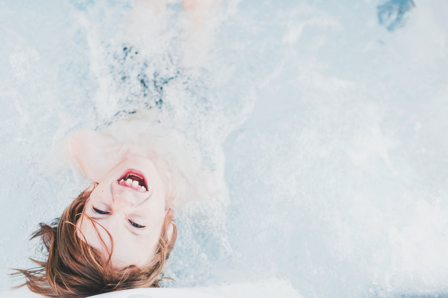 laughing kid playing in water photo by Frank Mckenna